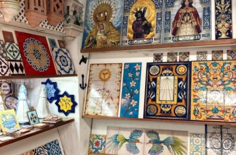 A photo of a tile shop in Seville, with rows of brightly patterned ceramic tiles of a variety of sizes on shelves.